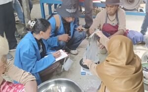 DARI MANUAL KE MESIN: Masyarakat KTH Warkamah mempraktikkan proses pengolahan briket arang secara manual dan menggunakan mesin screw press modern. Pendampingan ini bertujuan memperkenalkan teknologi tepat guna untuk mengoptimalkan produksi briket dari campuran serbuk gergaji dan limbah cangkang biji pala